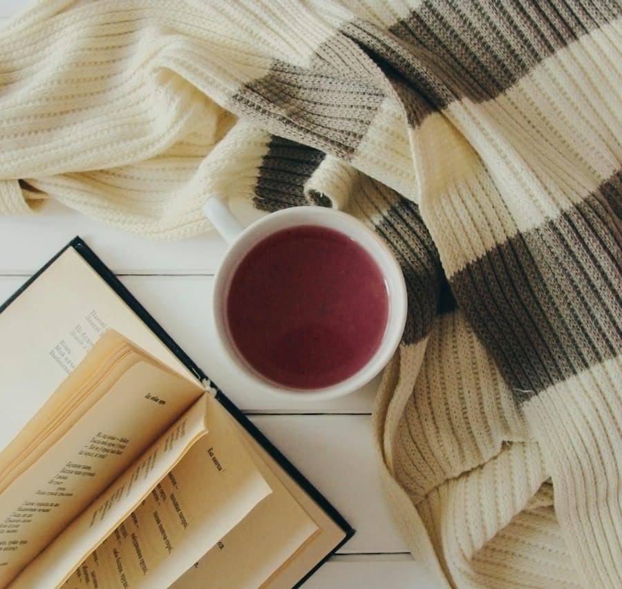 Gebreide plaid met een kop thee en een open boek