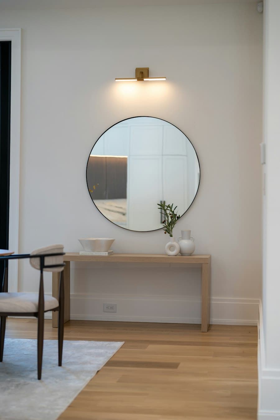 Ronde spiegel boven een houten wandtafel